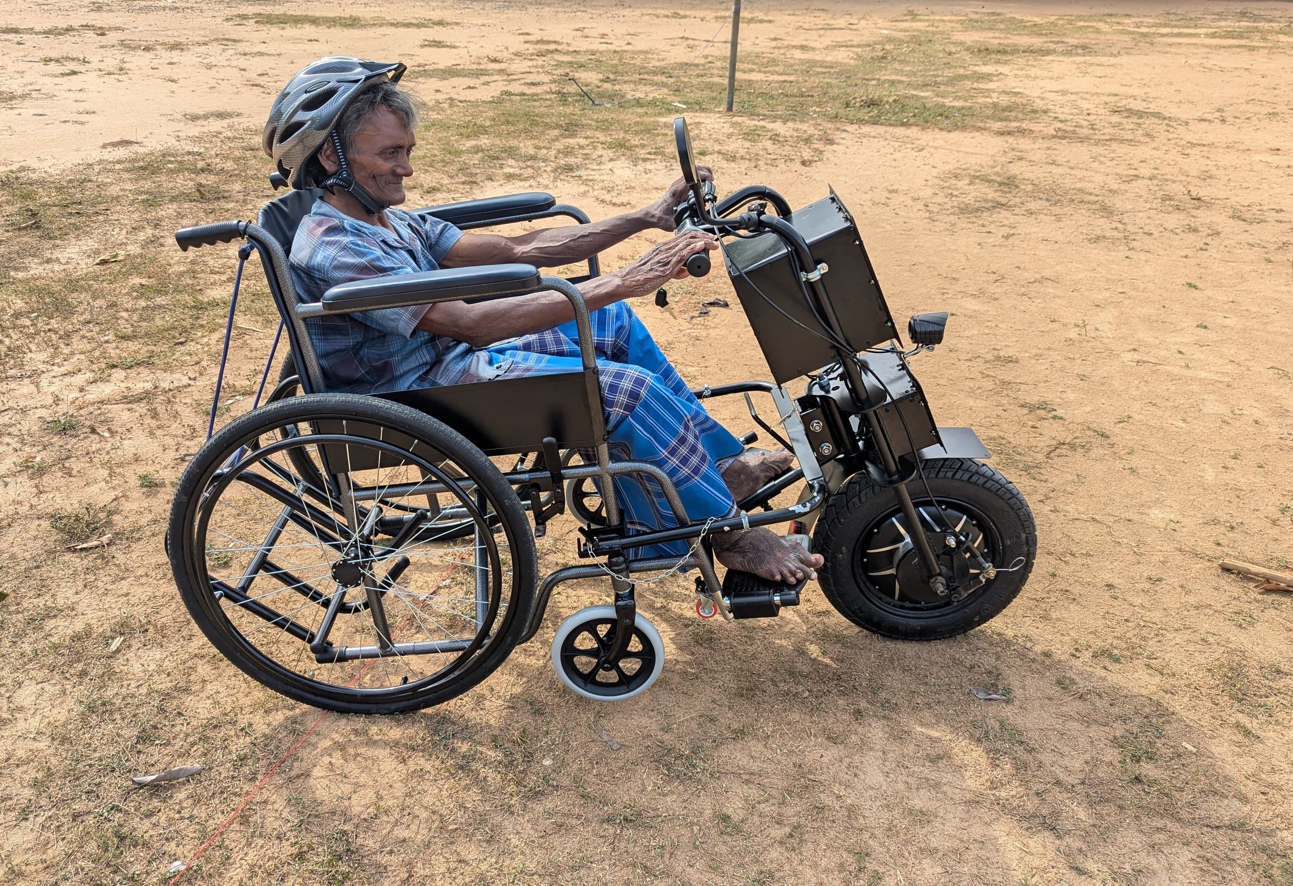 Kanthan setting off across open ground on his adaptive e-tricycle.